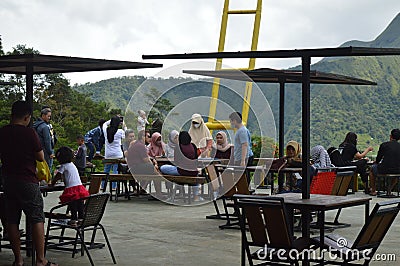 visitors to a cafe are resting and enjoying the view of the green hills in the Sembalun area Editorial Stock Photo